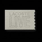 Etiqueta retangular de Zetex cinza claro vazada e gravada a laser com a marca Lacoste Live.