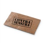 Etiqueta retangular de Zetex marrom amassado com o logotipo da marca Contra Sensura estampado em silk screen preto com acabamento em verniz.