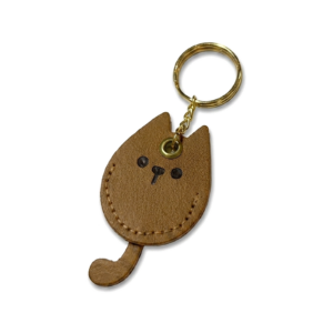 Chaveiro em formato de gatinho em couro sintético marrom com costura pespontada nas bordas e argola metálica no topo.
