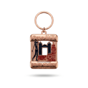 Chaveiro personalizado em metal com acabamento em tom de cobre, argola no topo e aplique retangular resinado com estampa colorida.