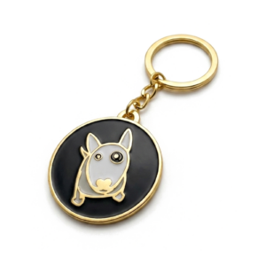 Chaveiro personalizado em metal com acabamento dourado, argola no topo e aplique circular resinado com desenho de um cachorro.